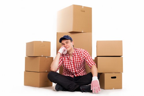 Movers carrying furniture through a residential property in North Kensington